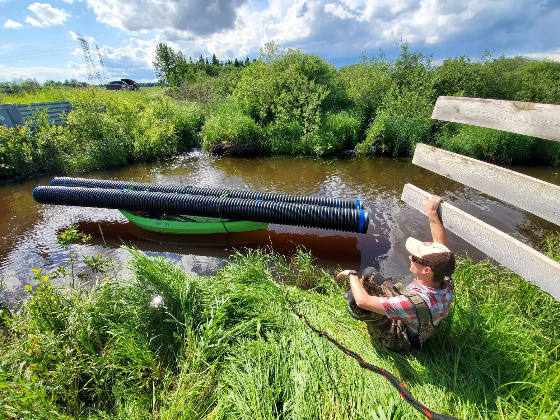 A length of pond leveller pipe balanced across a kayak on open water